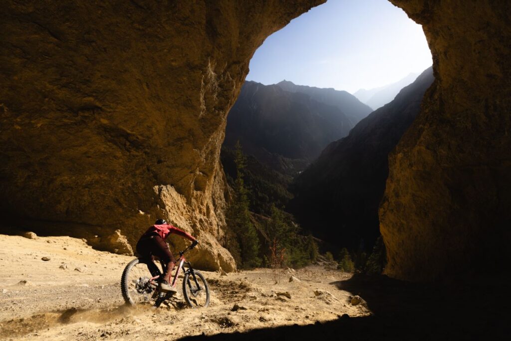 Mountain biker riding through rocky archway