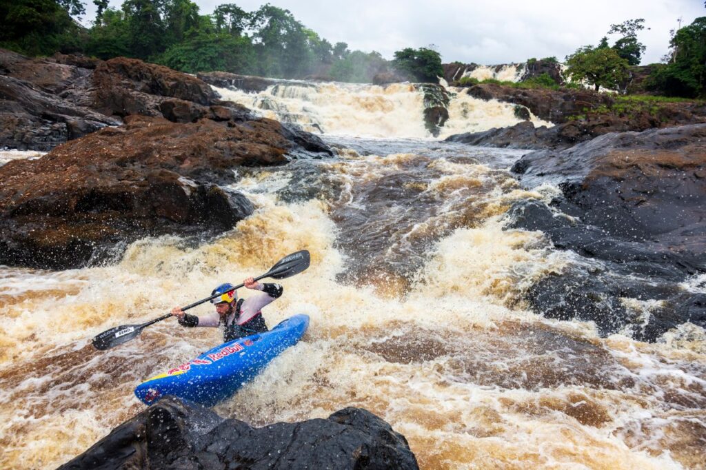 Kayaker navigating turbulent waterfall rapids - a scene from Gabon Uncharted
