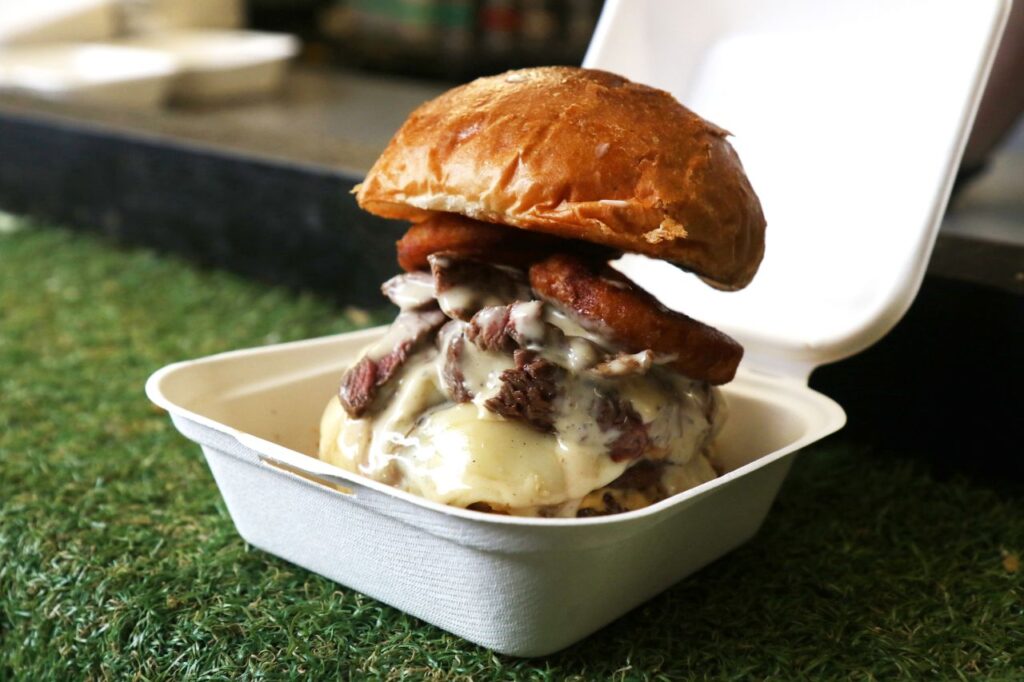 A loaded burger from The Burger Society sitting an open box