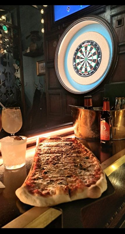 A sourdough pizza, with drinks and a dartboard