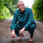 Miles Jupp in his jim jams, barefooted and in a street