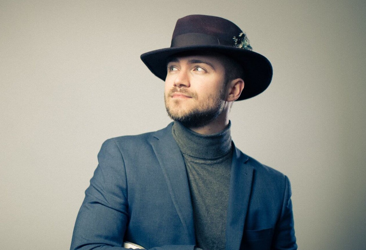 Thomas Heppell wearing a hat looking into the distance
