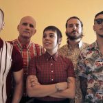 Los Fastidios band members standing in a row
