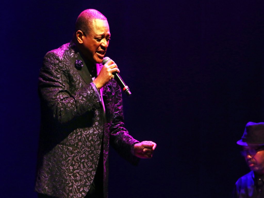 Original founding member of The Stylistics Airrion Love singing into a microphone