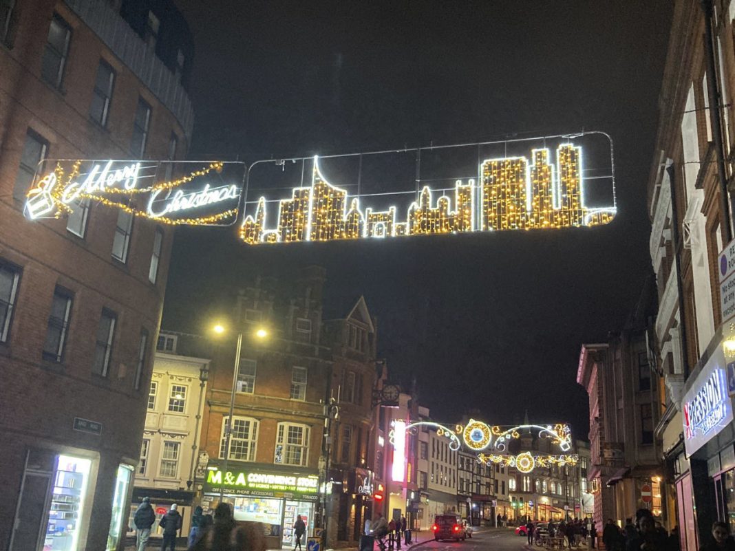 Reading's Christmas lights. This display shows an image of Reading's skyline, and in the background are shops and a lamppost. The image has been taken at night so the lights are on