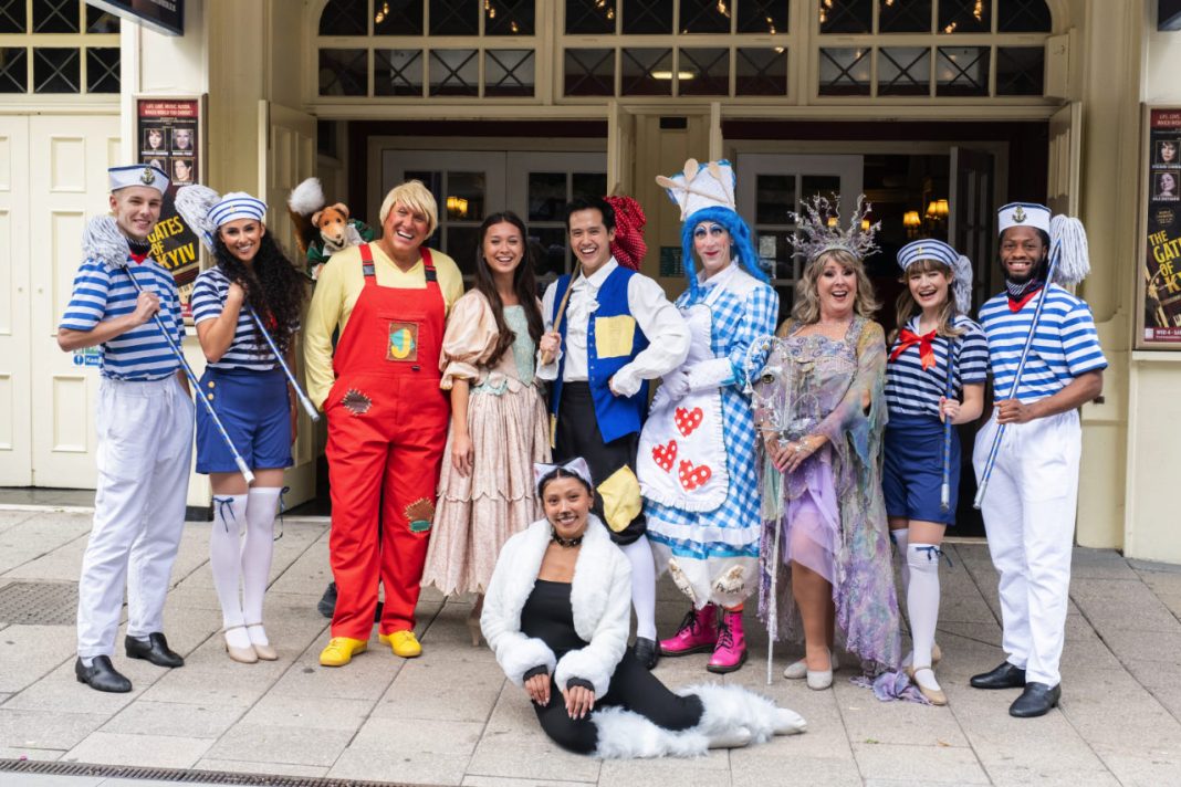 The cast of Dick Whittington, the 2024-25 pantomime at Theatre Royal Windsor outside the theatre entrance