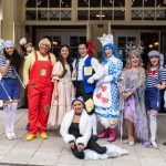 The cast of Dick Whittington, the 2024-25 pantomime at Theatre Royal Windsor outside the theatre entrance