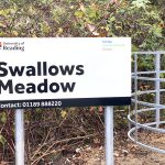 The sign at the entrance of Swallows Meadow and part of the kissing gate