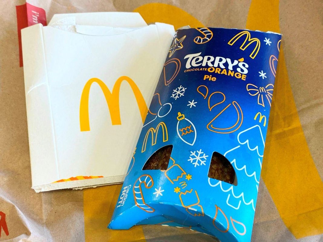 The Terry's Chocolate Orange pie in a blue festive-style package. It sits on top of a McDonald's bag and a cardboard holder with the McDonald's M on it