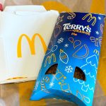 The Terry's Chocolate Orange pie in a blue festive-style package. It sits on top of a McDonald's bag and a cardboard holder with the McDonald's M on it