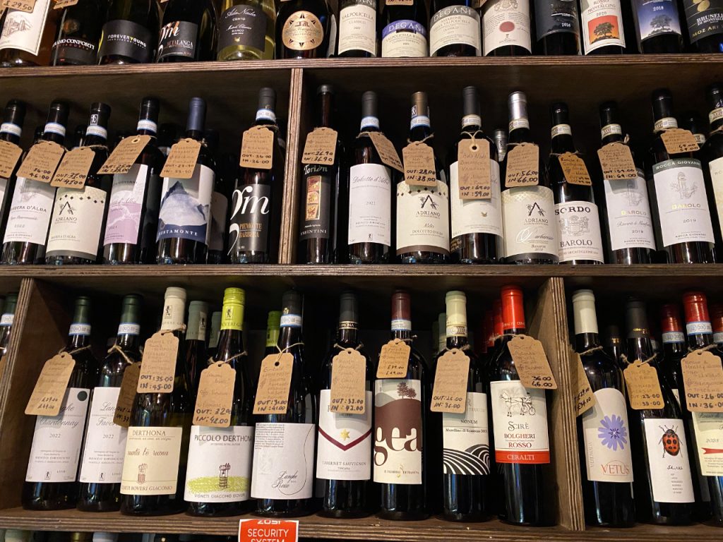 A selection of Italian wines. Each bottle has a luggage tag attached to it detailing more information about the wine