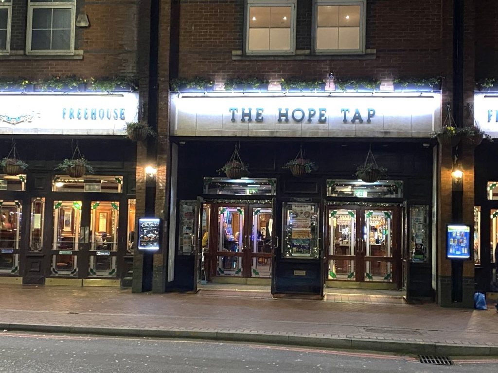 The entrance to The Hope Tap on Friar Street. It is lit up as it was taken at night