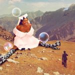 Sophie Duker sitting on a hill with a man and a woman in the mountains