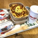a tray of food on a table at Wendy's including two burgers, two sets of fries and a drink