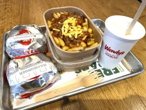 a tray of food on a table at Wendy's including two burgers, two sets of fries and a drink