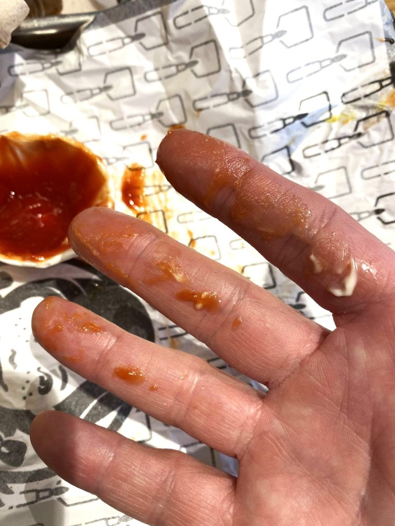 a hand with ketchup on it