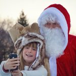 Santa Claus with a young child taking a selfie
