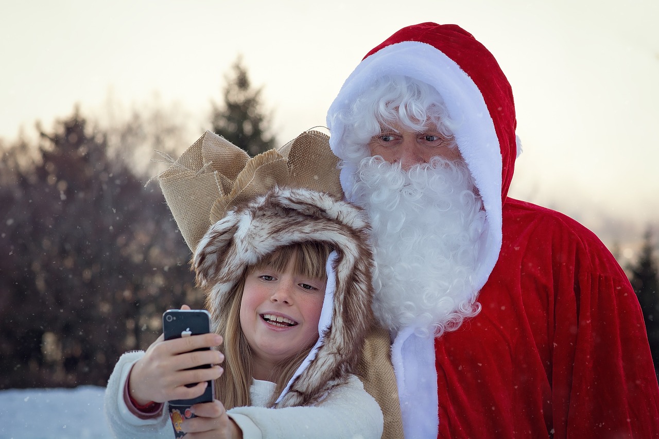 Santa Claus with a young child taking a selfie