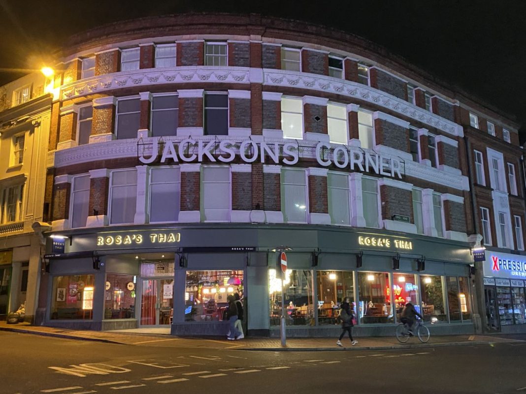 a corner building with a sign on the front - Rosa's Thai at Jackson's Corner