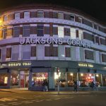 a corner building with a sign on the front - Rosa's Thai at Jackson's Corner
