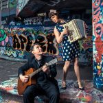 a man playing an instrument next to a woman to promote the Oh la la! Quintet