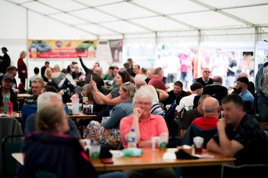 People drinking beer in a marquee
