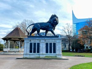 The Maiwand Lion statue and bandstand in Forbury Gardens with The Blade in the background. The venue is the home of Reading Children's Festival opening event, the Forbury Fiesta
