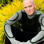 Mr C sitting down against a yellow background