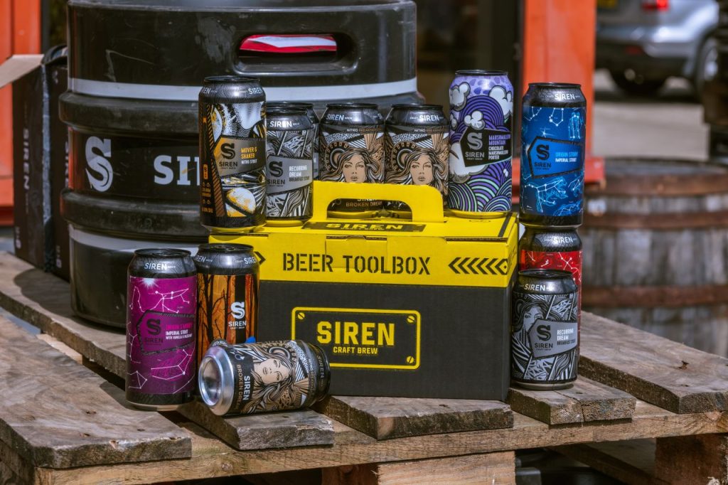 Some of the beers in the Siren Craft Brew tool box gift set laid out on a bench