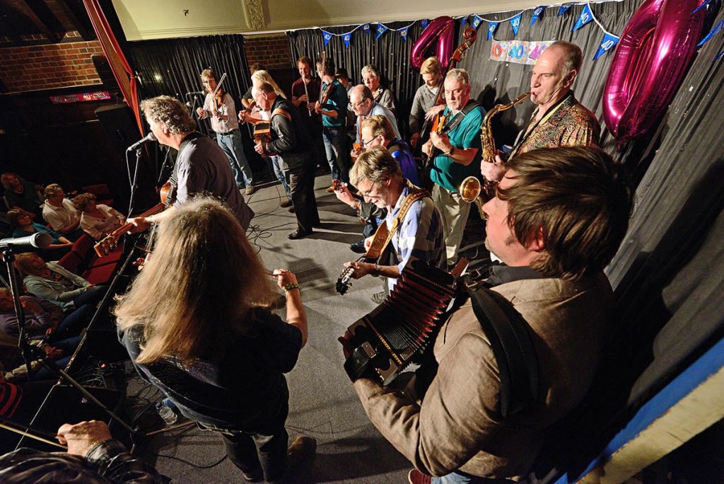 Musicians on stage with different instruments helping Nettlebed Folk Club celebrate its 40th anniversary