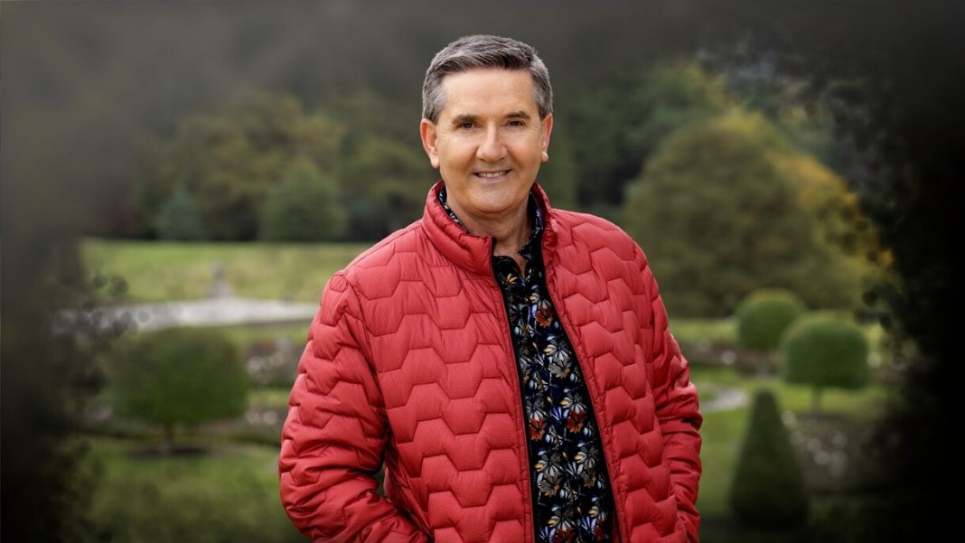 The singer Daniel O'Donnell in a red jacket standing outdoors