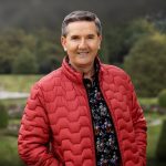 The singer Daniel O'Donnell in a red jacket standing outdoors