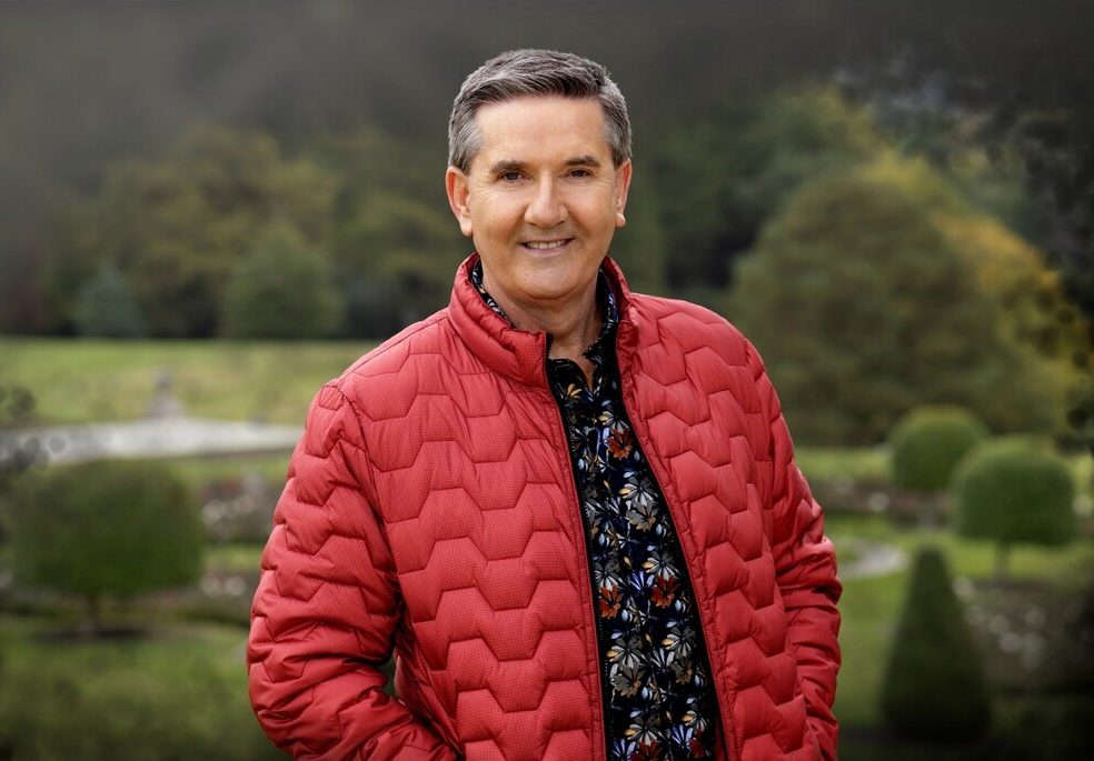 The singer Daniel O'Donnell in a red jacket standing outdoors