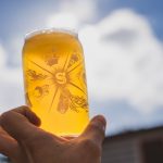 A glass of Lumina beer held up to the sunlight