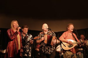 Four musicians performing on the stage of Nettlefield Folk Club