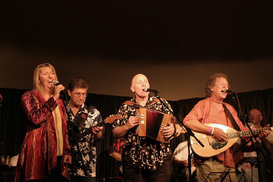 Four musicians performing on the stage of Nettlefield Folk Club