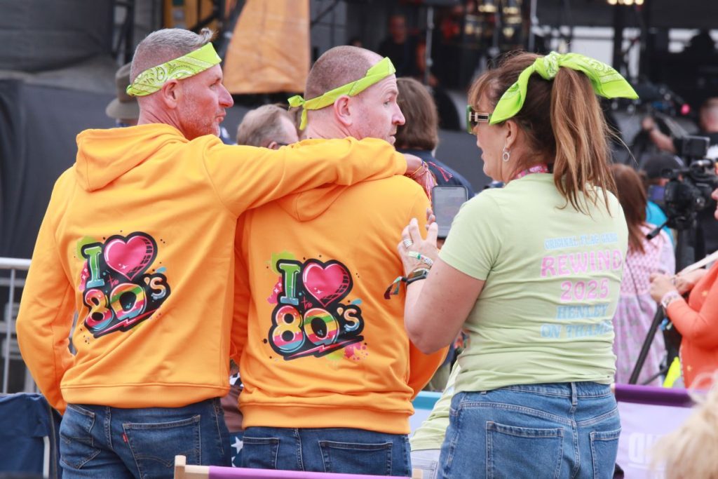 Two people wearing T-shirts that say 'I HEART 80s' with a third person next to us. They have their backs to the camera