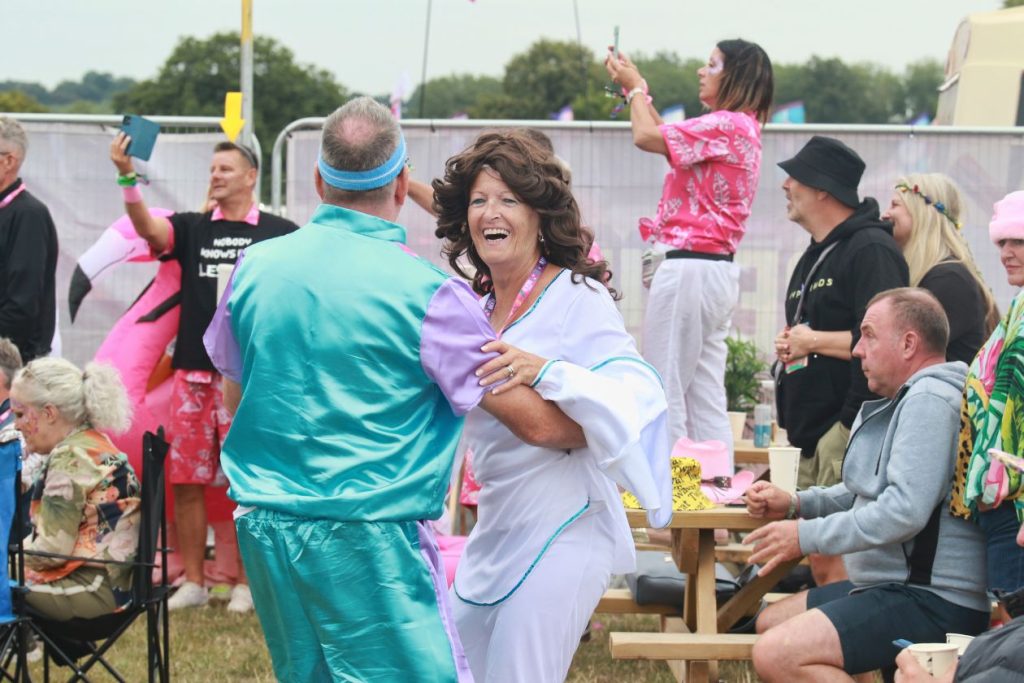 A couple wearing 80s clothes dancing