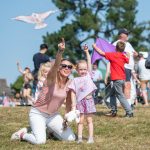 Norden Farm's Kite Festival – a woman and a child flying a kite looking happy