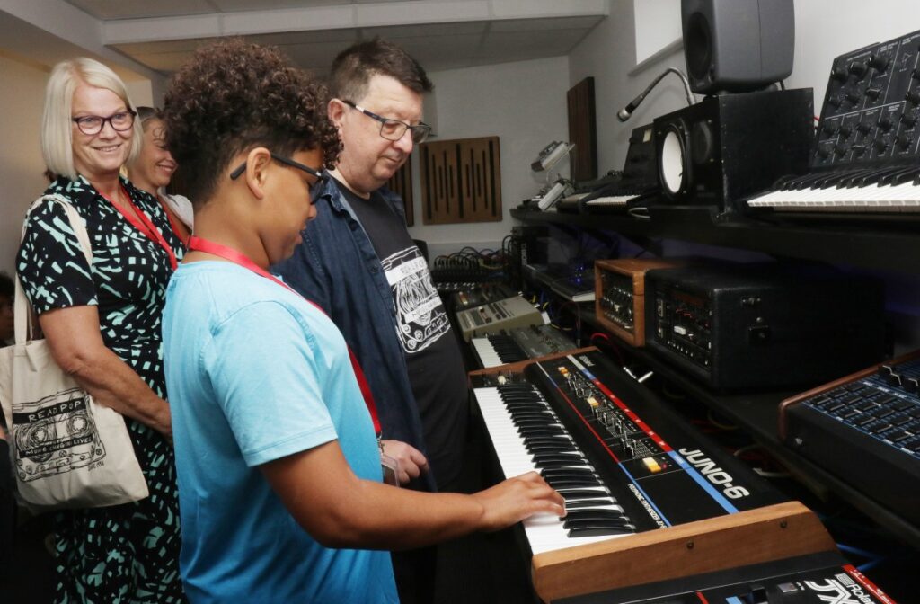 A young visitor to Readipop is given an opportunity to test the keyboards in the studios, helped by Gavin Lombos 