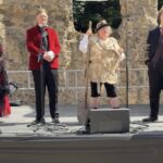 A rehearsal image for Progress Theatre's Hamlet showing four actors in a line on a stage that has been erected in Reading's Abbey Ruins, which can be seen in the background