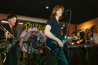 The Amazons performing on stage at The Purple Turtle, featuring Matt Thomson on lead vocals and guitar alongside guitarist Chris Alderton